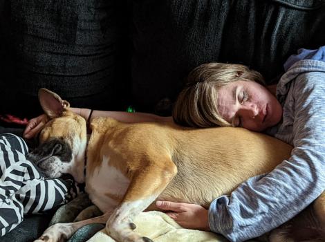 Person sleeping beside Bailey the bulldog